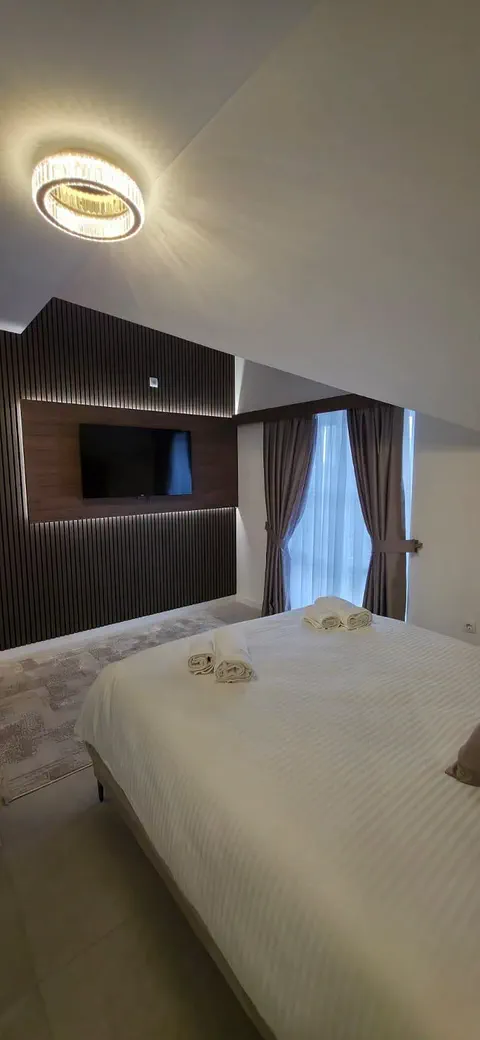 Apartman 2 — TV na zidu od drvenih letvica i prozor sa zavjesama