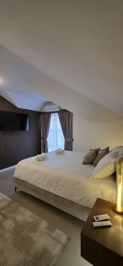 Apartman 4 — TV na zidu od drvenih letvica, prozor i klima uređaj